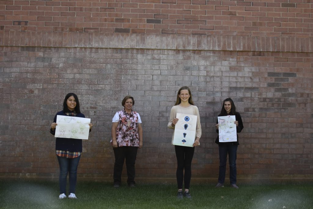 Photo of students and their art work.